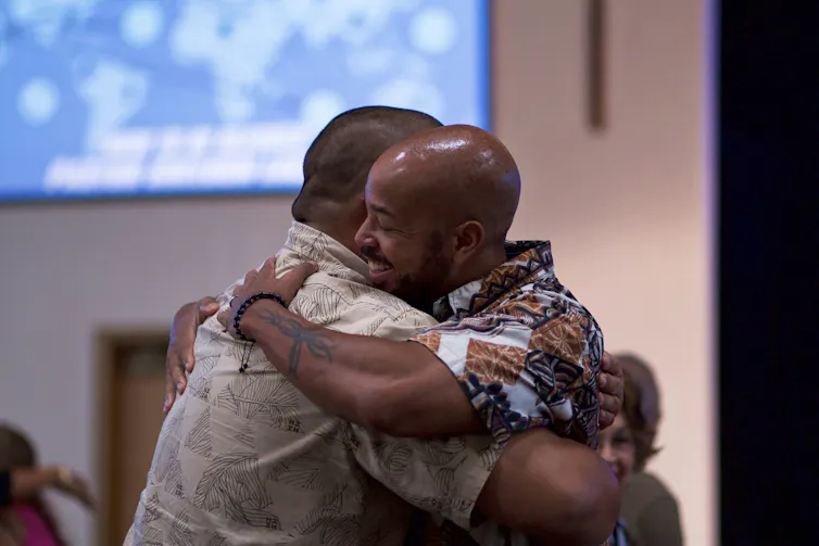 two older men hug