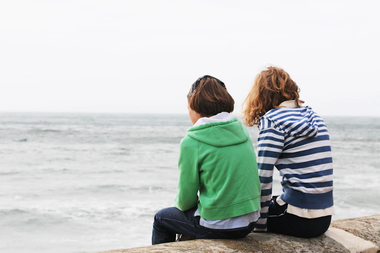 Young people sat looking out to sea