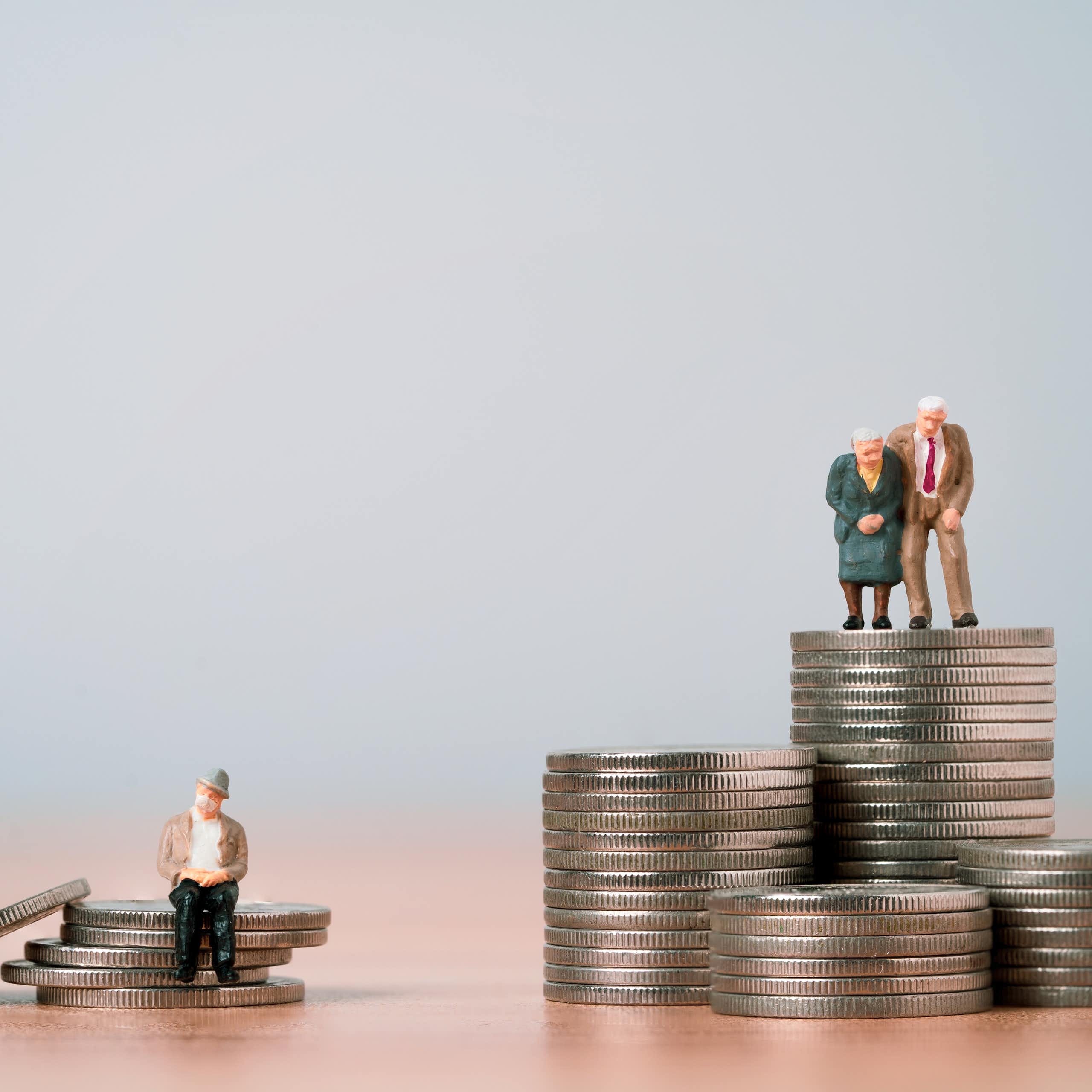 deux figurines représentant des personnes âgées sur un tas de pièce de monnaie