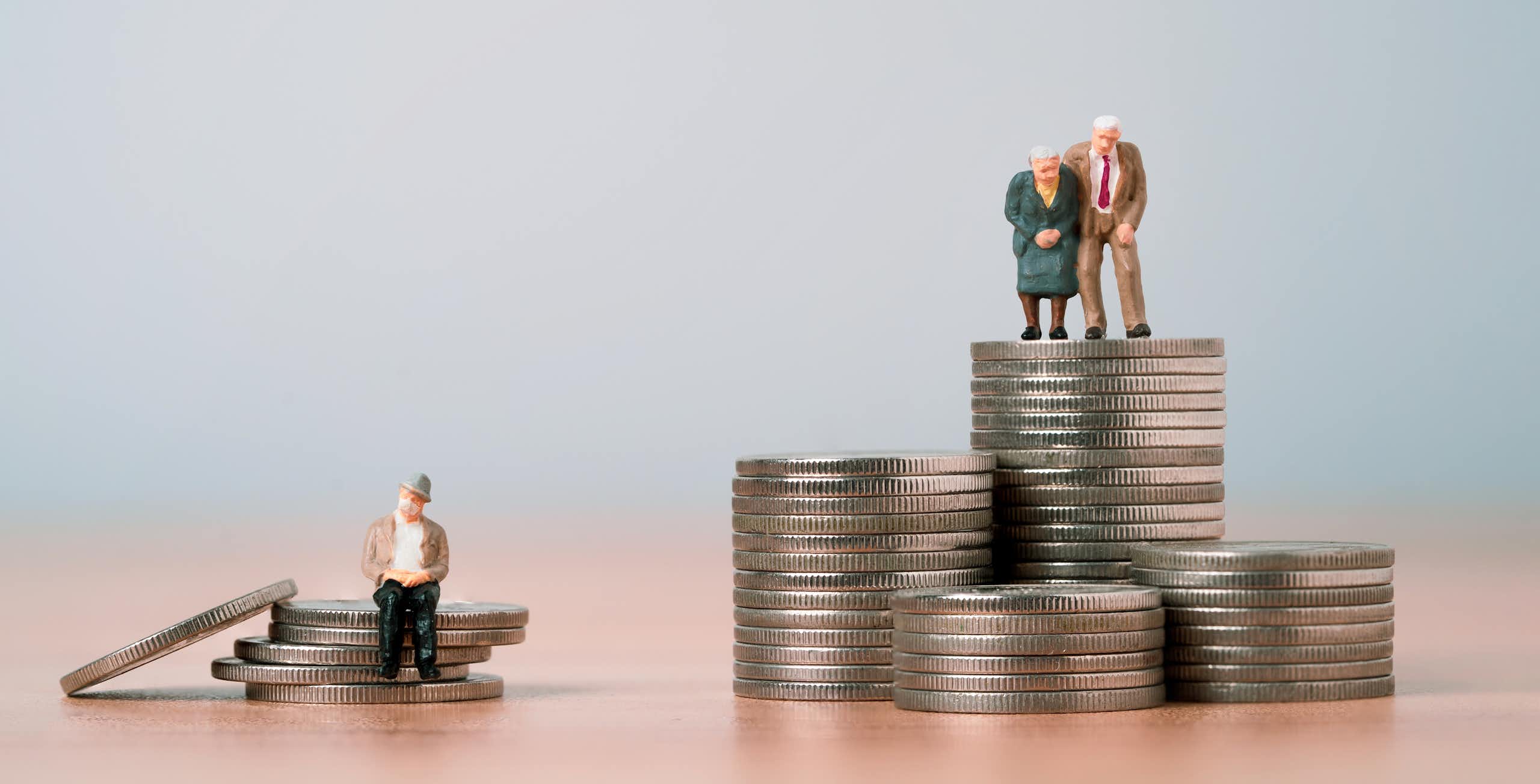 deux figurines représentant des personnes âgées sur un tas de pièce de monnaie