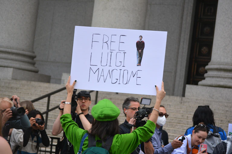 Supporter of Luigi Mangione holds a sign that reads "free Luigi Mangione"