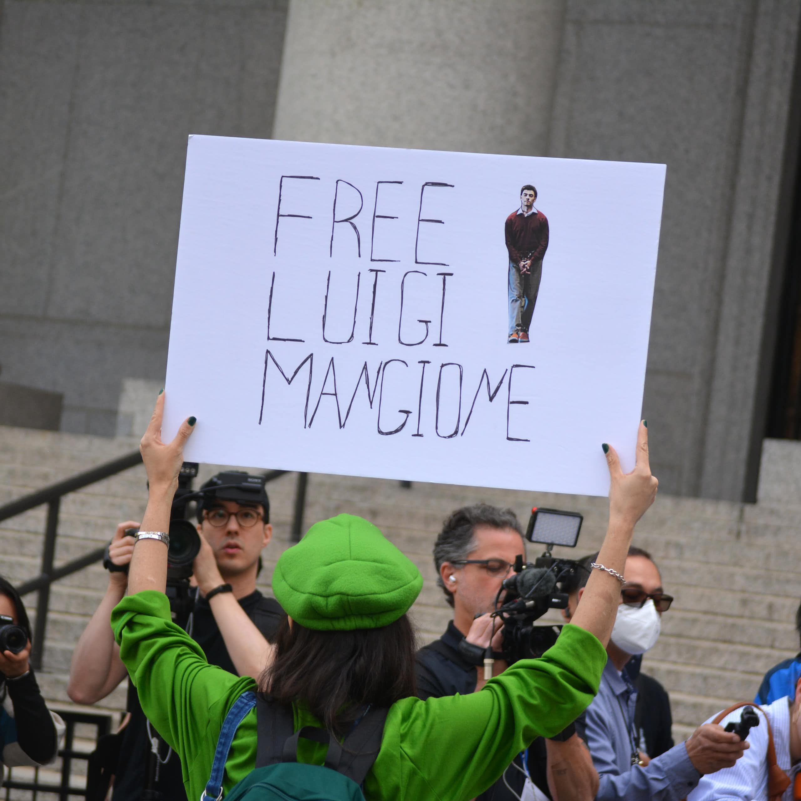 Supporter of Luigi Mangione holds a sign that reads "free Luigi Mangione"