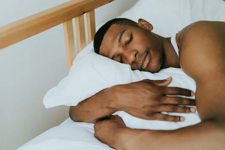 Un homme endormi sur un lit