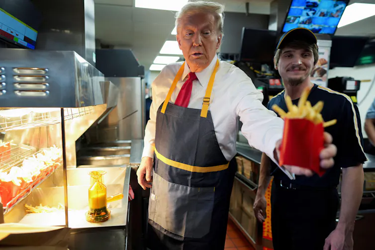 Donald Trump handing a box of fires to a customer in a McDonalds.