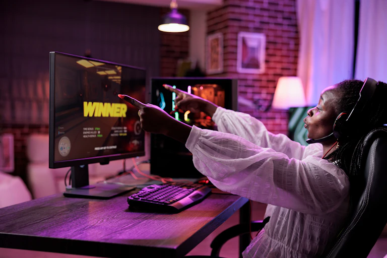 Woman playing a video game on her computer. The screen says 'winner'.