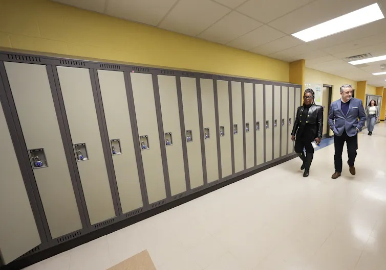 Los dos adultos vieron el despertar del pasillo de la escuela con armarios.