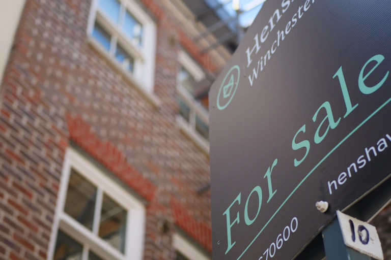 for sale sign outside a brick-fronted houw