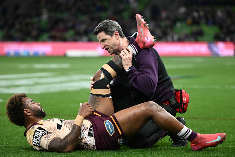 Ezra Mam of the Broncos is treated for an injury during the NRL clash against the Storm.