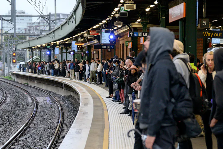 People standing on a platform waiting for a train.