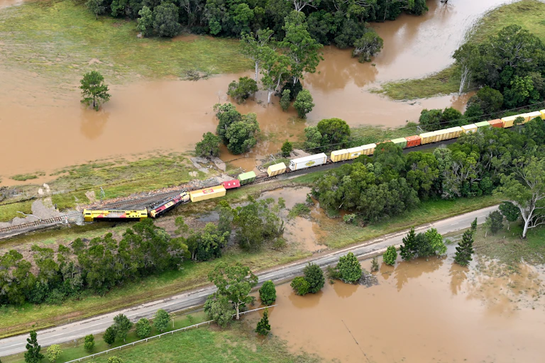 An aerial photo of a derailed train amid floodwaters