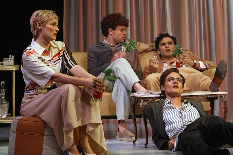 Production image: four young people lounge around.