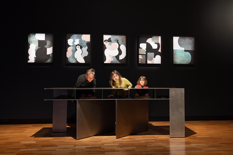 A mother and two children experience the artwork.