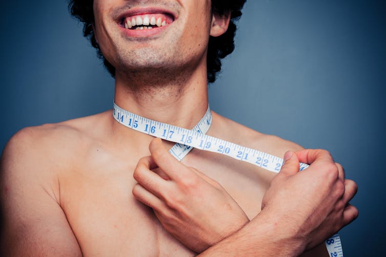 A man with a tape measure around his neck.