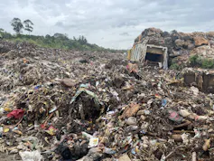Un terrain ouvert recouvert d'un tas de déchets très haut, sans contrôle ni recyclage