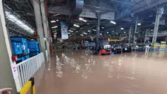 The inside of a factory with high water levels from floods and only the tops of cars available.