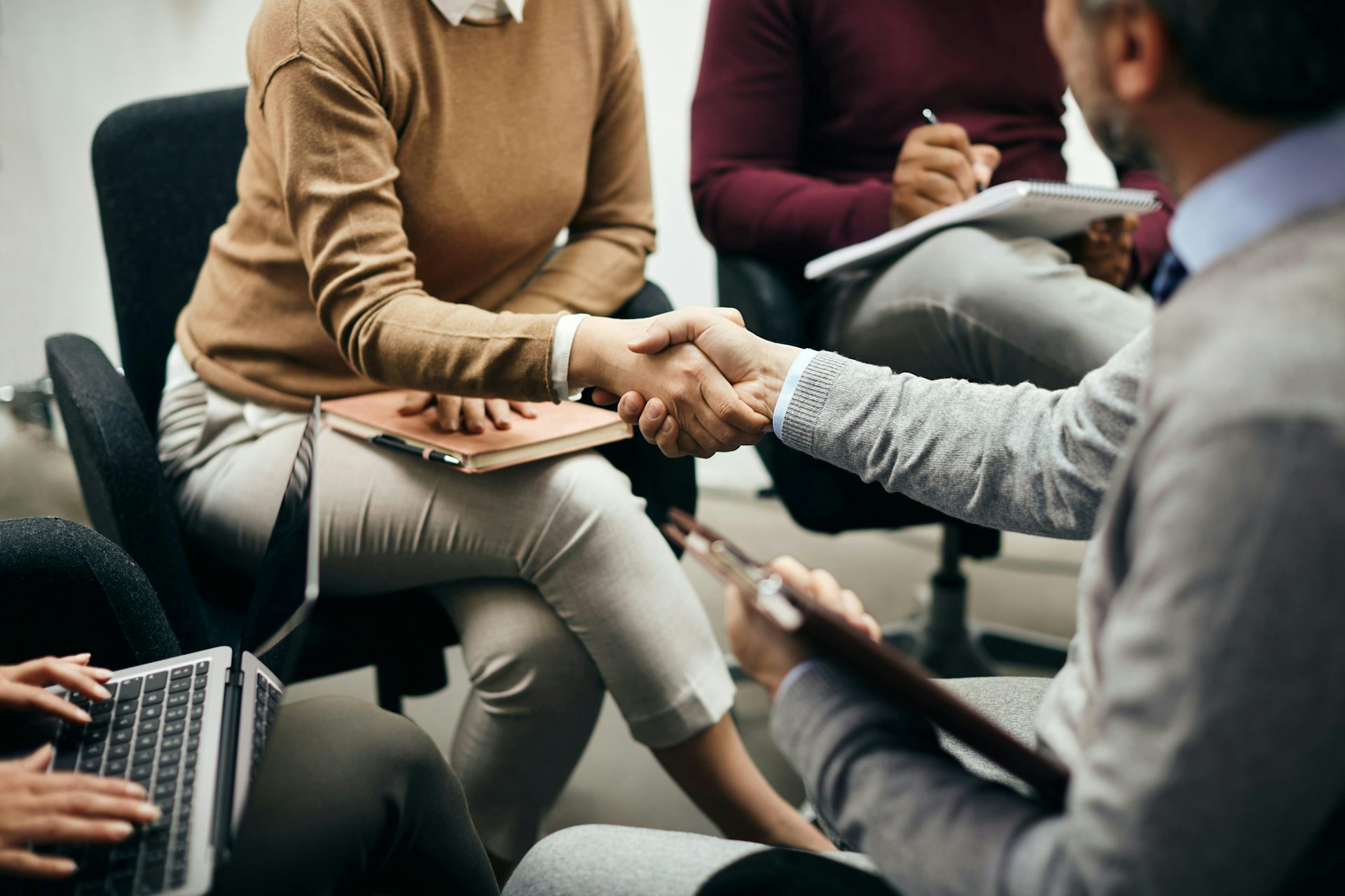 Two people shaking hands while seated