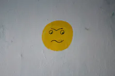 A cartoon face that looks angry, pained or confused.