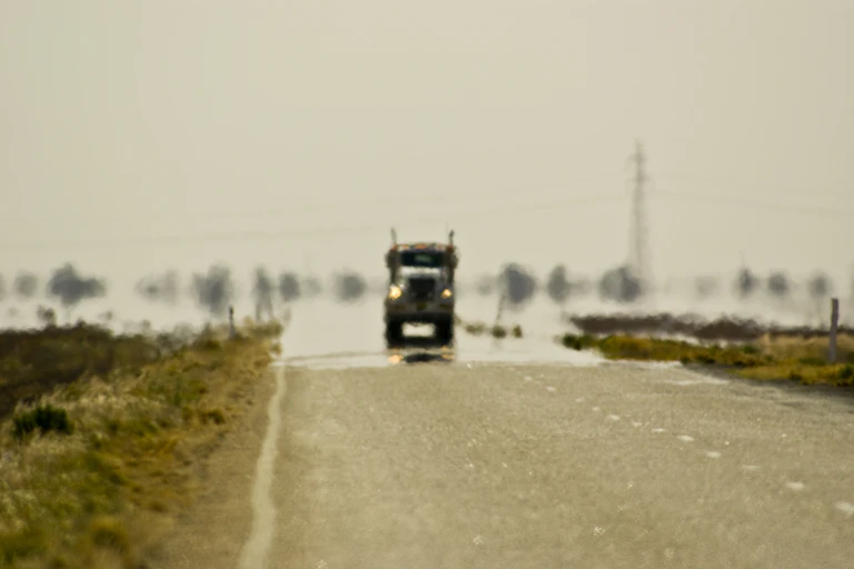 heat shimmer on highway as a truck nears the camera