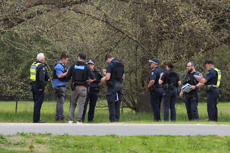 Police officers standing next to a country road