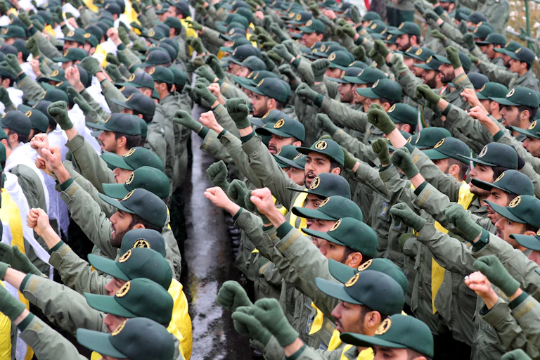 Rows of soldiers in uniform holding a fist in the air as a salute