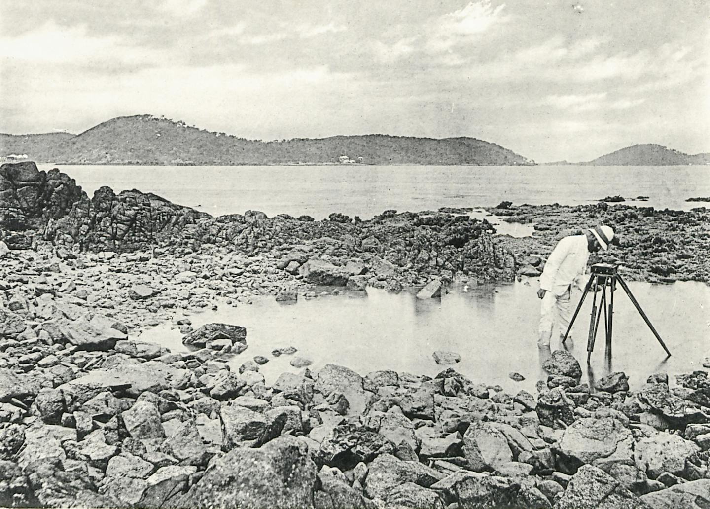 man taking measurements on a coastline.