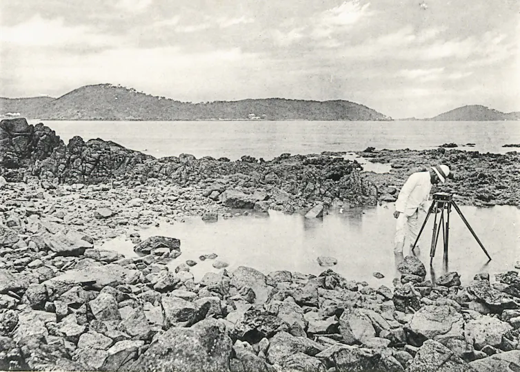 man taking measurements on a coastline.