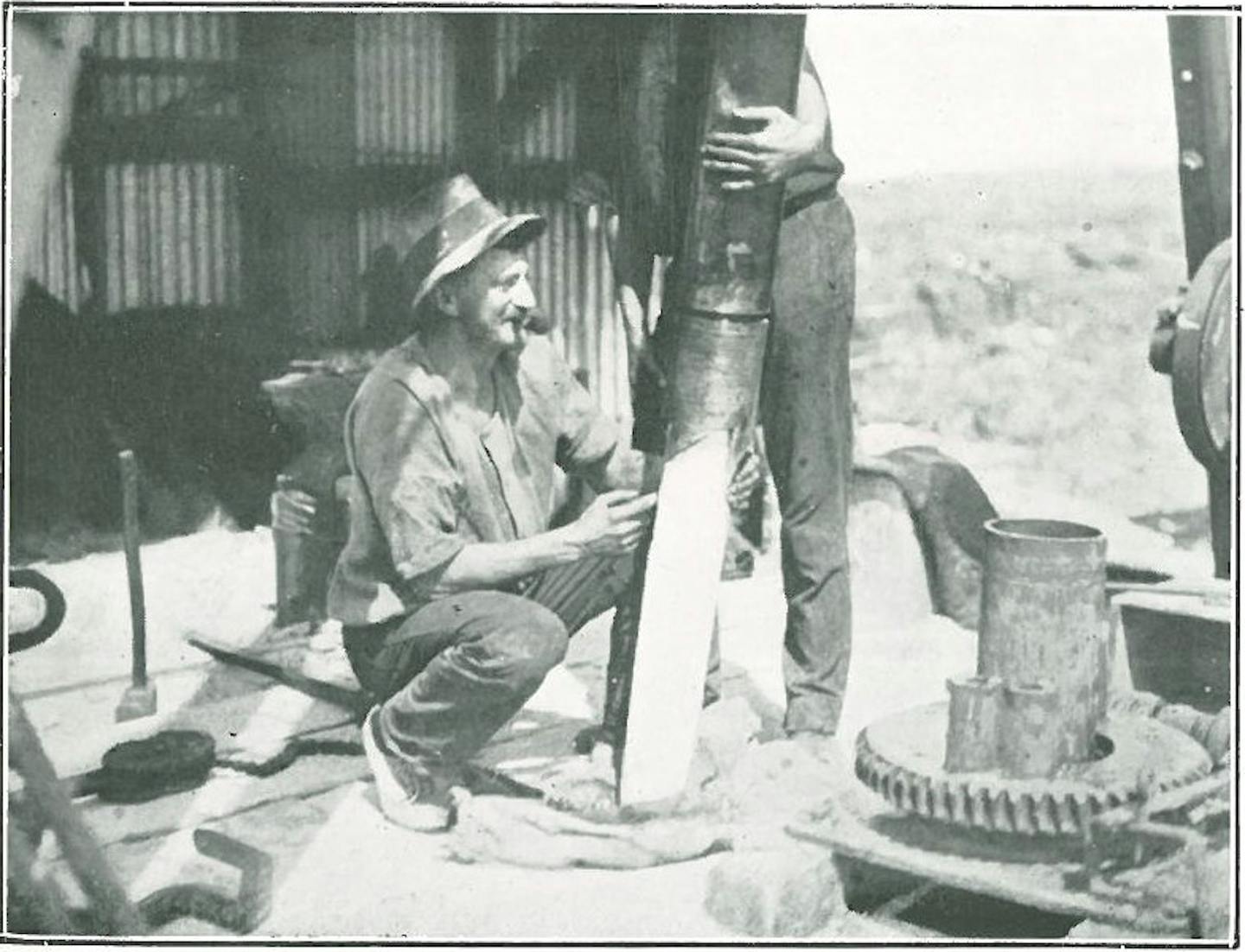 man with drilling equipment on boat with coral core drilled from reef.