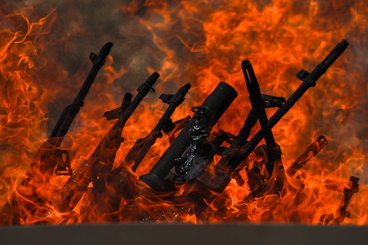 Several guns are shown being burned.