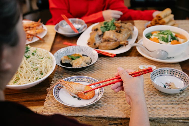 A family eats prawns and poultry at dinner.