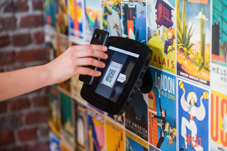 A person's hand holding a phone up to scan a QR code