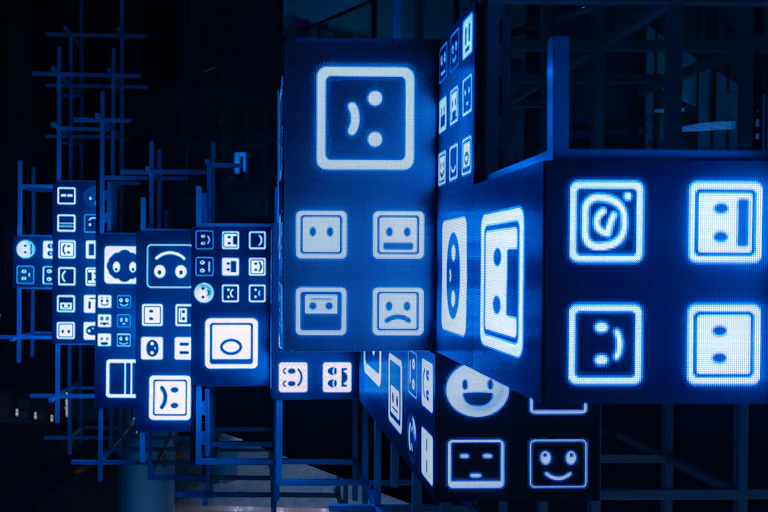 An art installation in a dark room with various computer symbol emotes on the walls.
