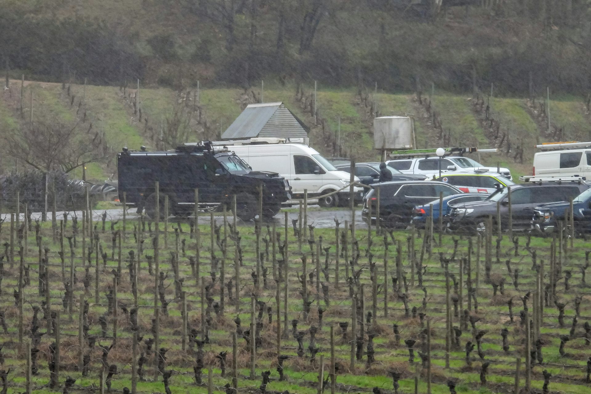 A black, armoured Bearcat vehicle is seen near the search area.