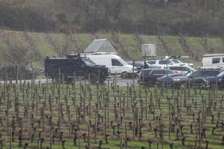 A black, armoured Bearcat vehicle is seen near the search area.