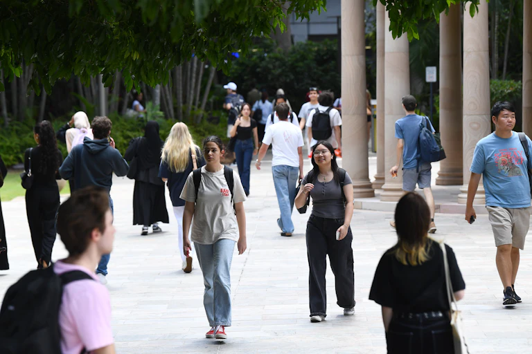 Students walk outside at a university campus.