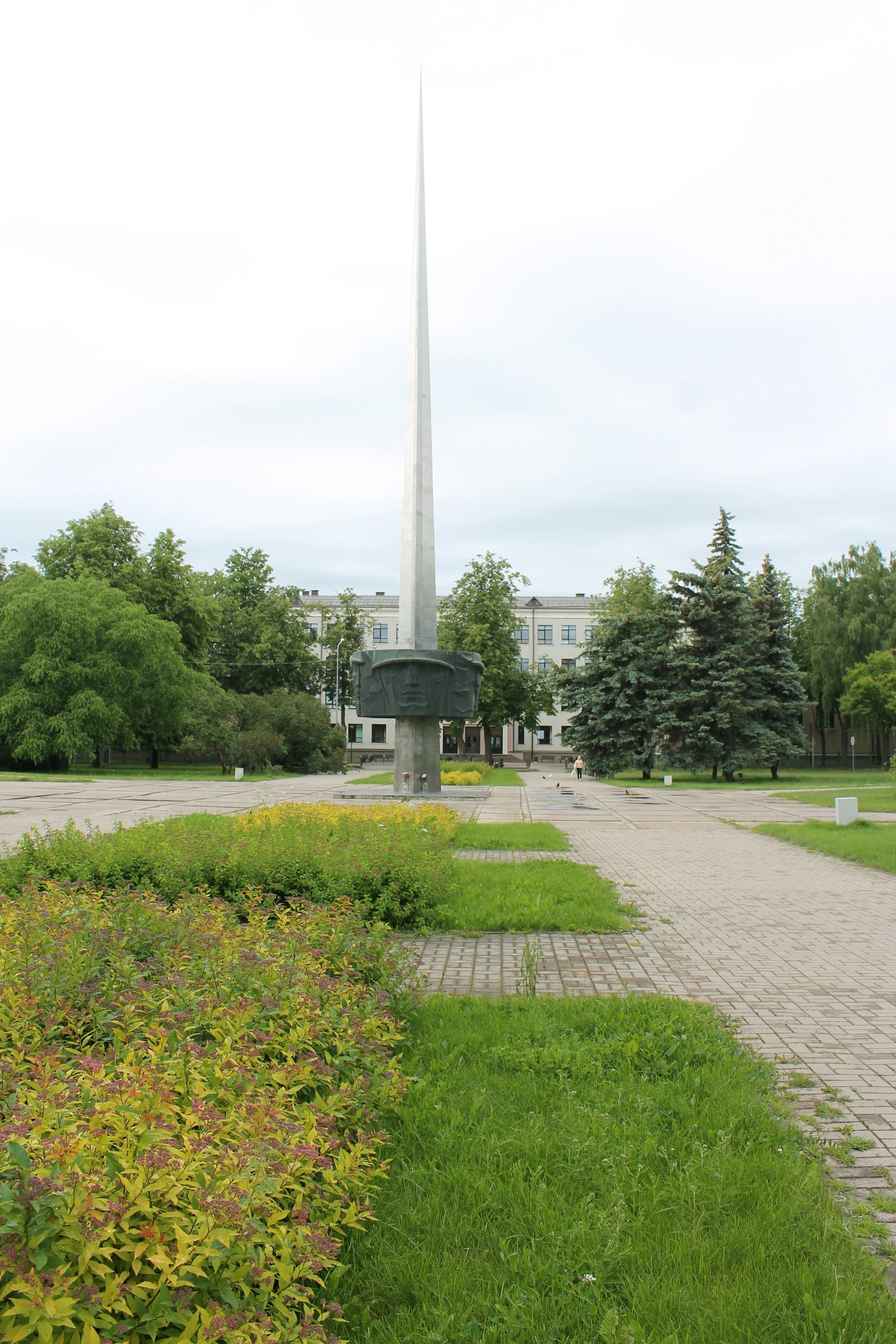 A tall Soviet-era monument in a public square in a Latvian city.