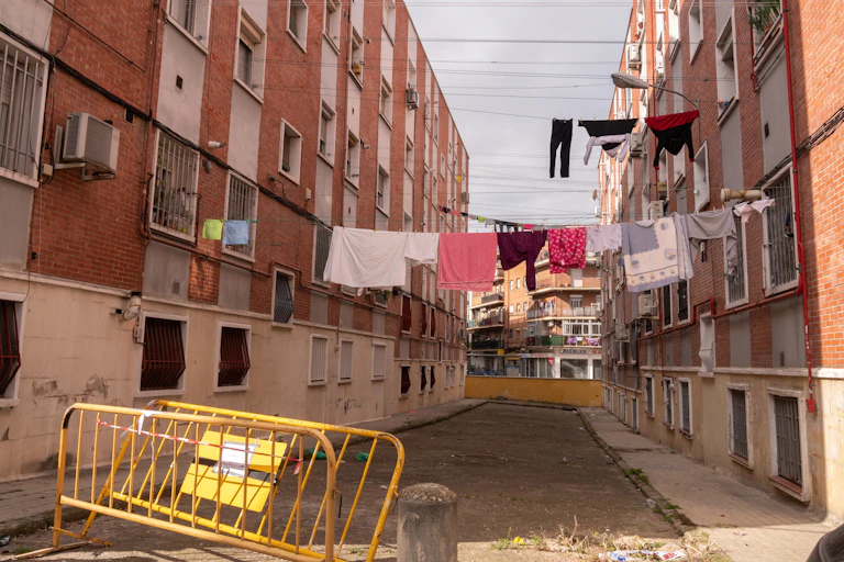 Una calle con ropa colgada y edificios antiguos de ladrillo rojo