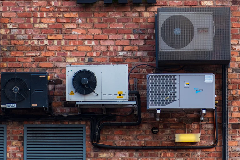 Air conditioning units attached to a red brick wall