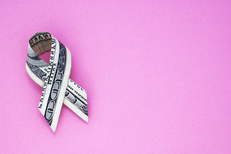Hundred dollar bill folded into shape of cancer fund-raising ribbon.