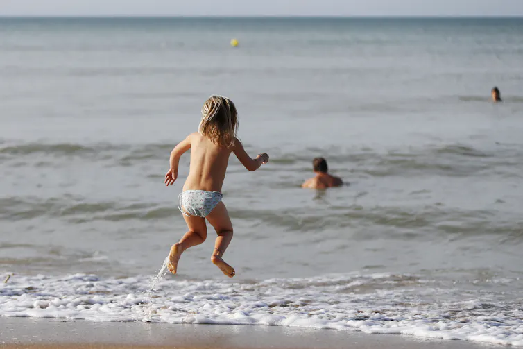 Un enfant profite de la plage par une journée ensoleillée d’automne dans la ville de Cabourg, au nord-ouest de la France, le 13 octobre 2018