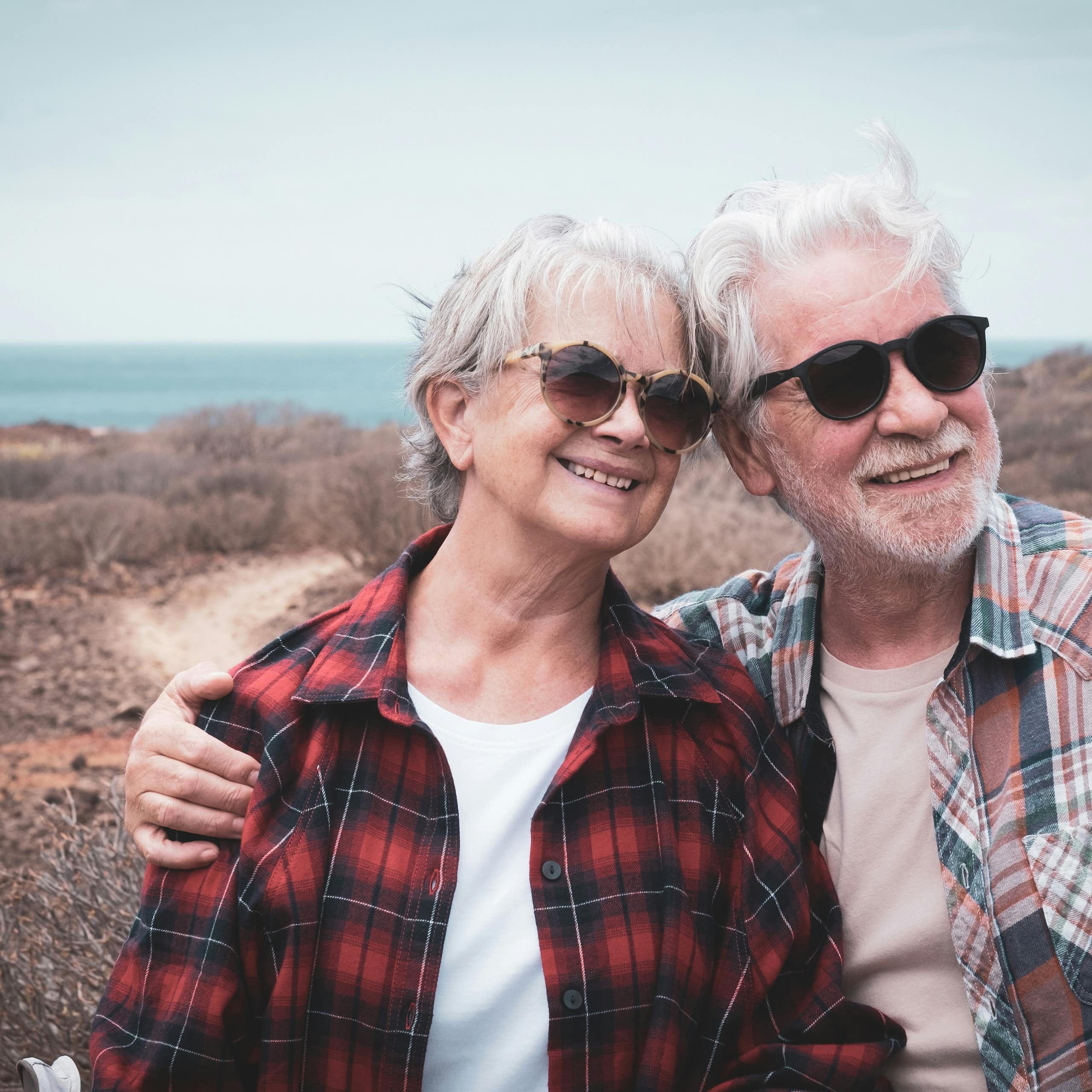 Deux personnes âgées regardent l'horizon en souriant