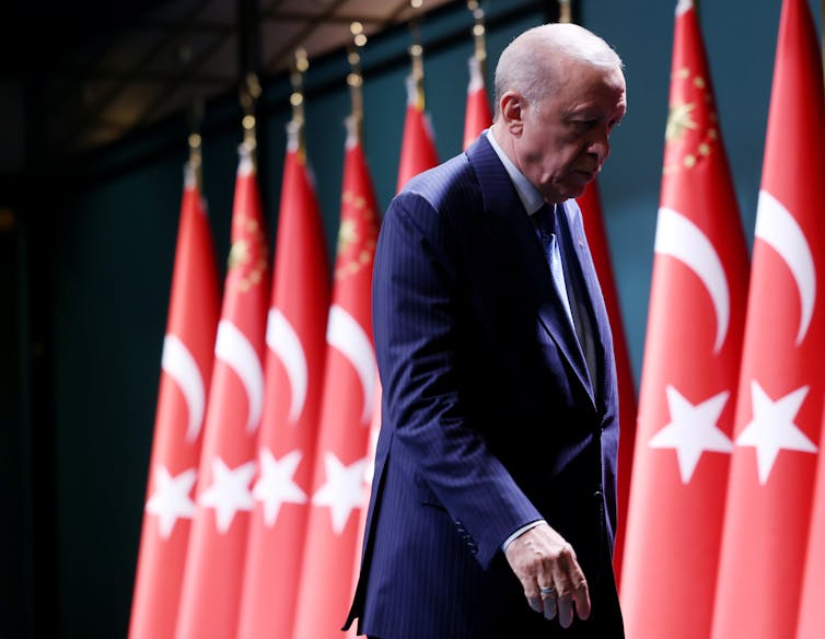A man walks next to a row of flags.