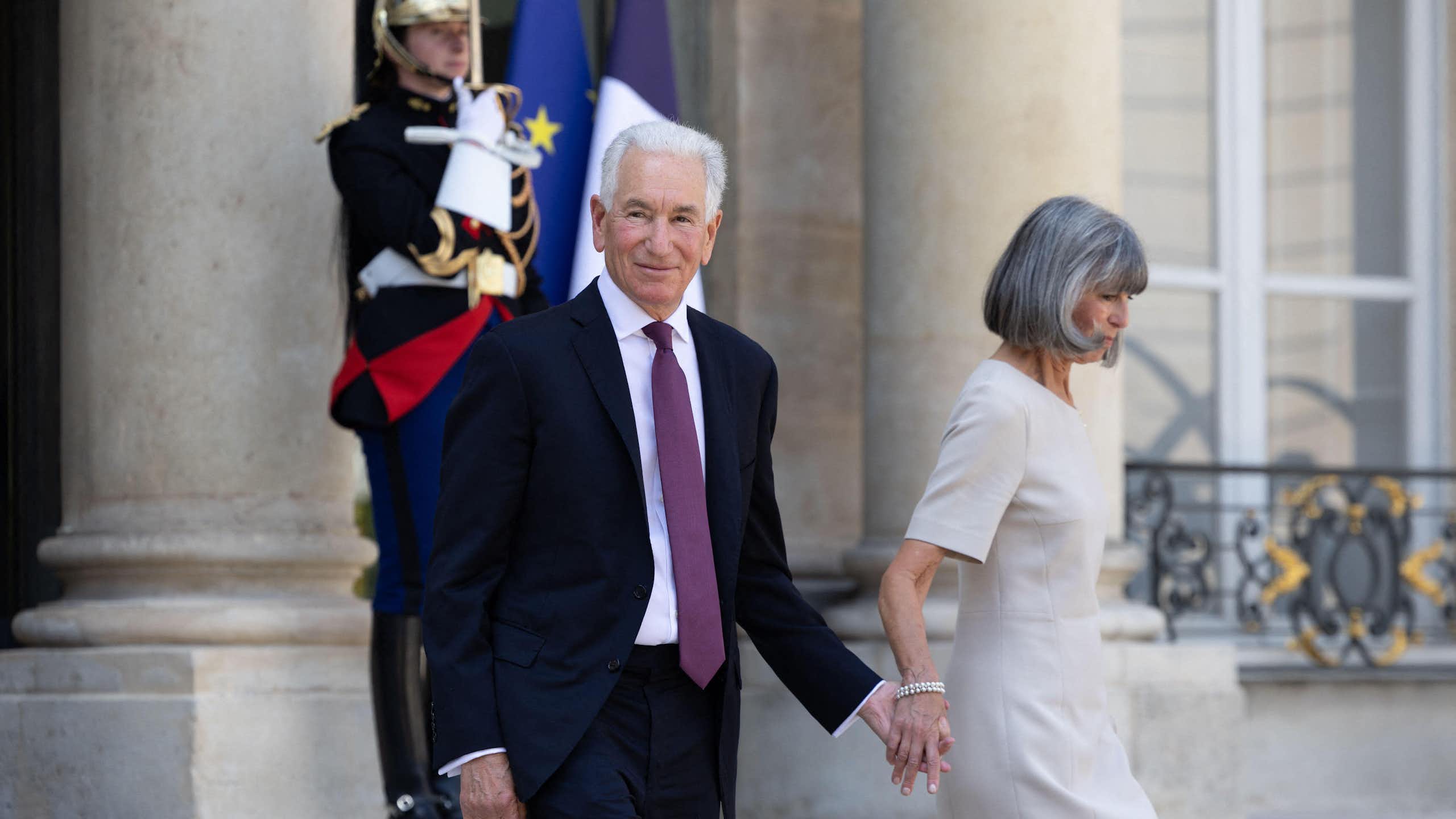 Charles Kushner, the new US ambassador to France, and his wife Seryl walk down steps at the Elysee Palace in Paris.