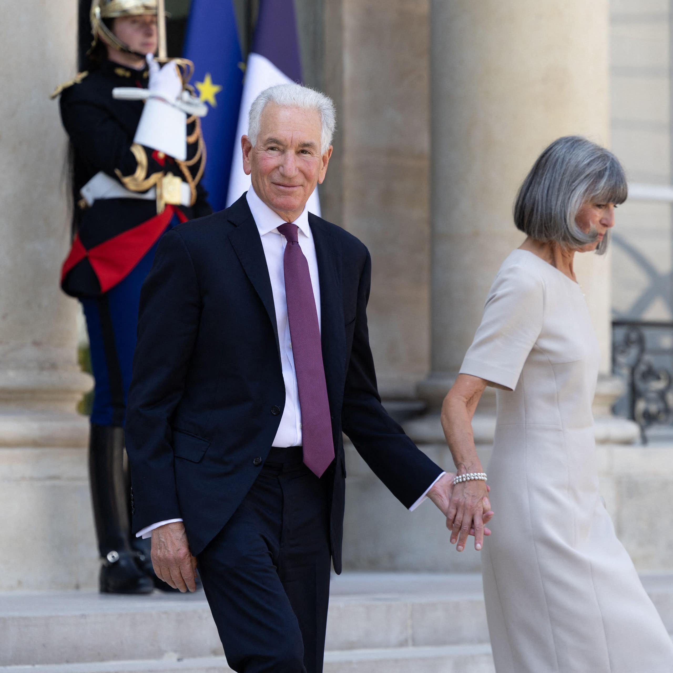 Charles Kushner, the new US ambassador to France, and his wife Seryl walk down steps at the Elysee Palace in Paris.