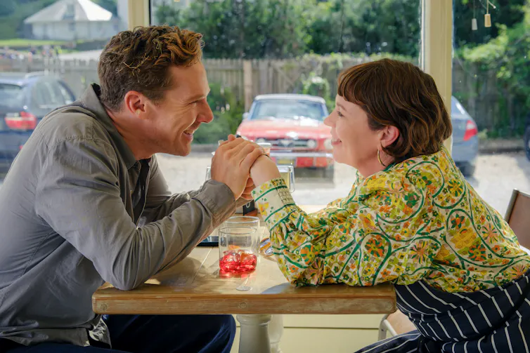 The Roses holding hands at a table
