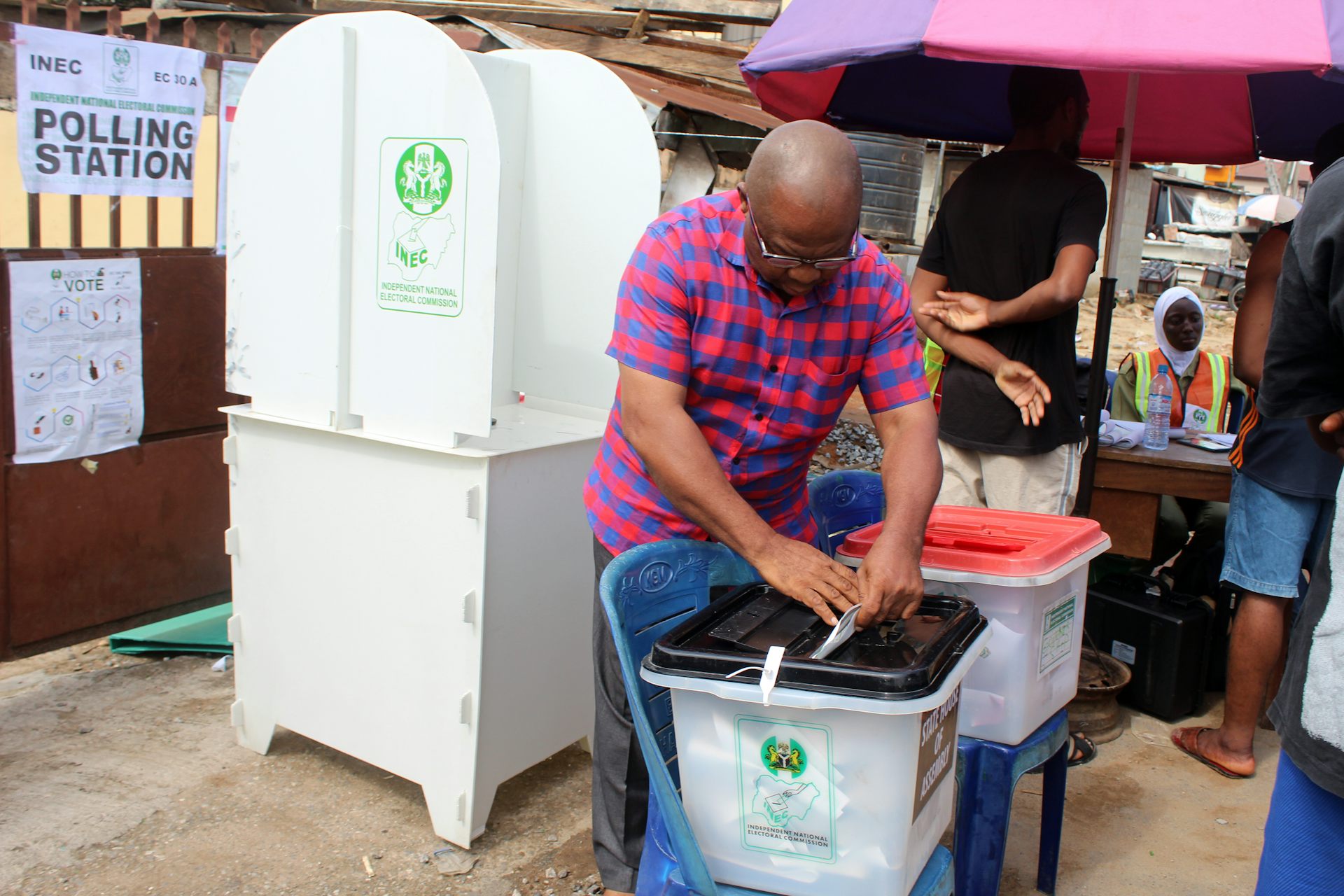 A man places a piece of paper in a plastic container
