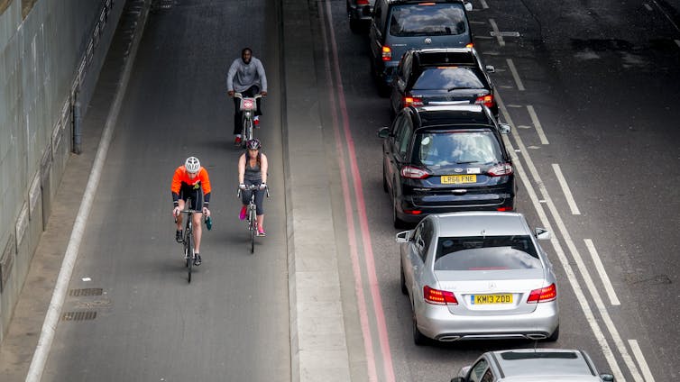 An aerial view of a cycle lane next to a row of cars.