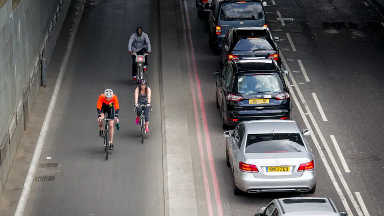 An aerial view of a cycle lane next to a row of cars.