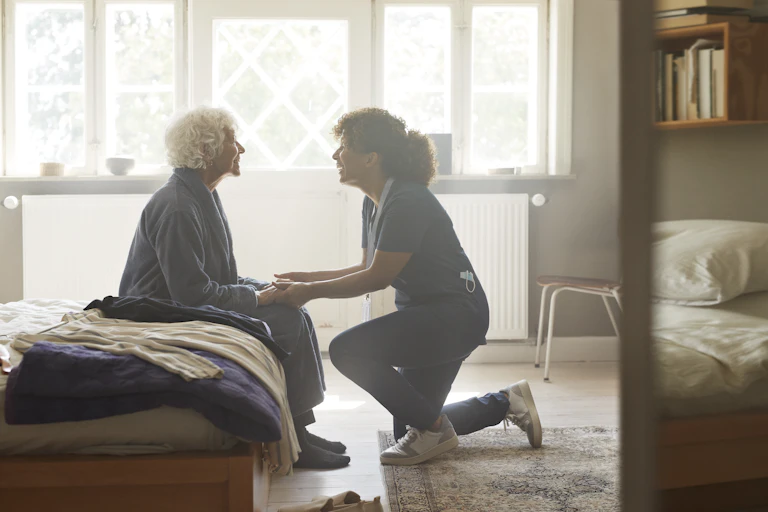 Carer holds the hands of an ageing patient