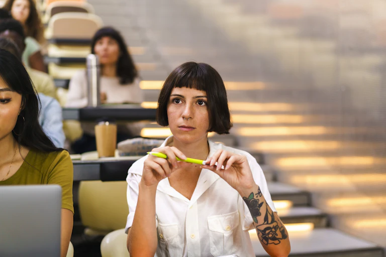 A young woman sits in a lecture hall.