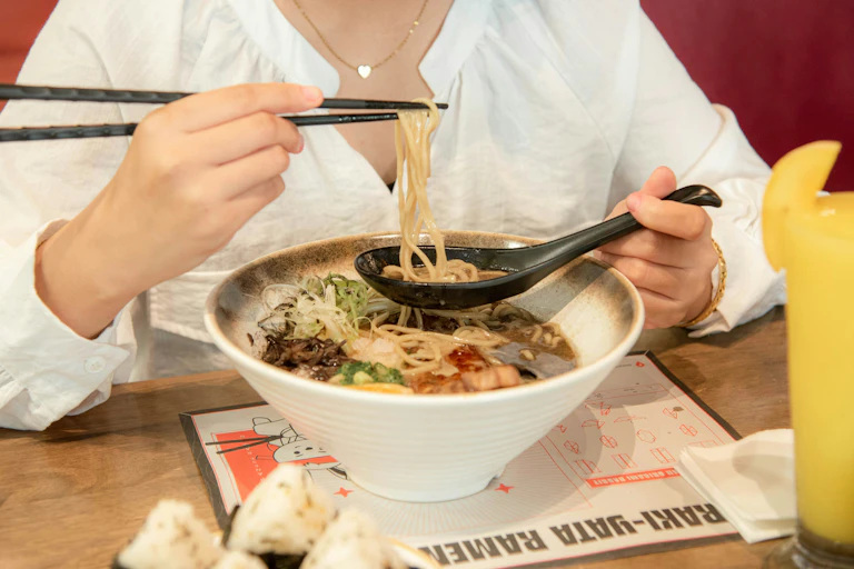 A woman eats ramen
